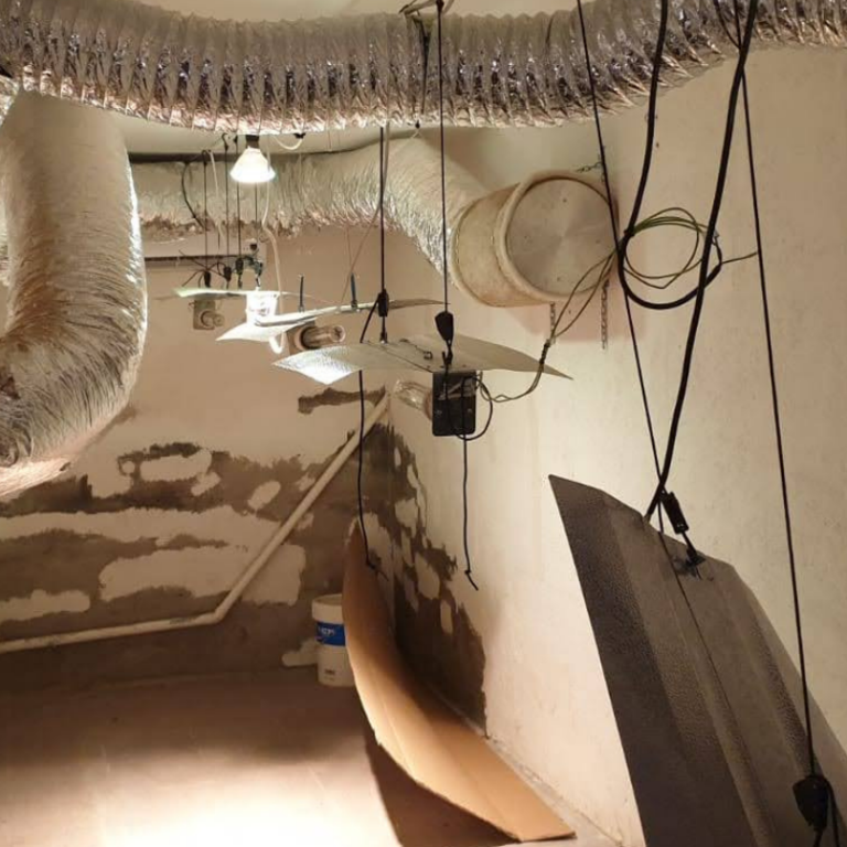 daños vandálicos Espacio interior con tuberías, luces y objetos colgantes en un entorno desordenado.